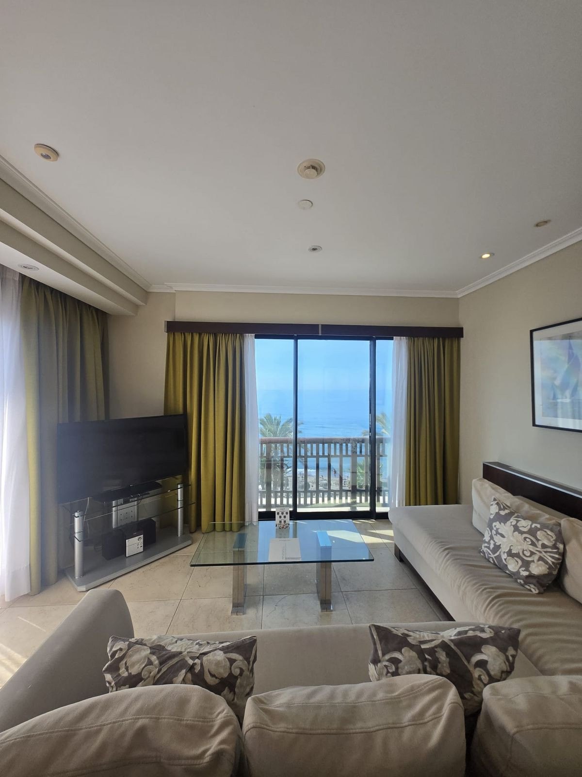 The living room, balcony doors open to the sea