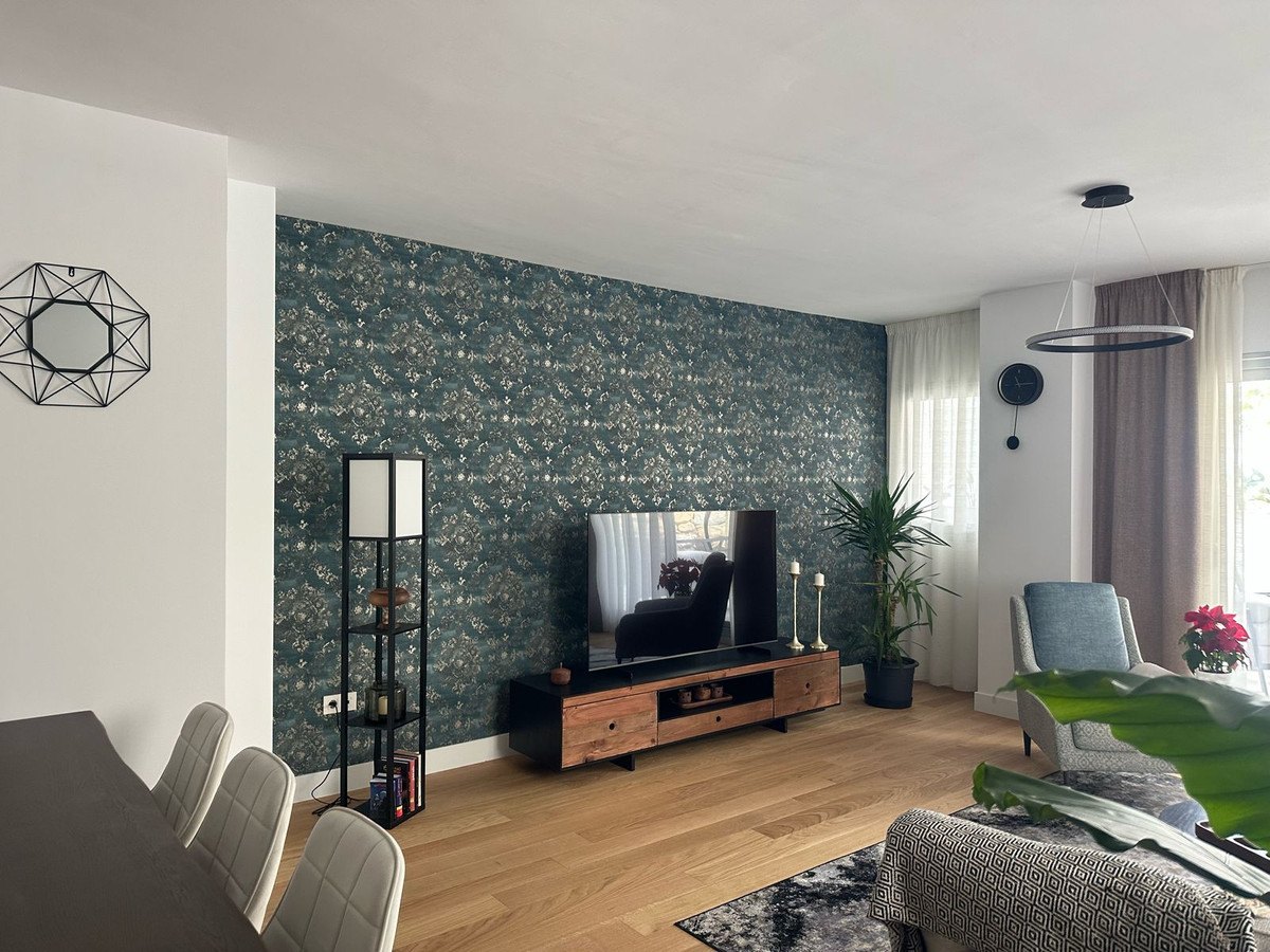 The living room with its wood floor and grey sofa
