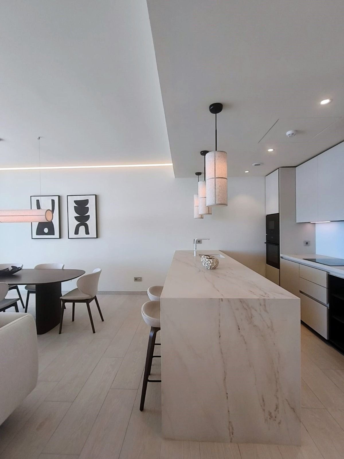 The kitchen island seen from its end, pendant lights above