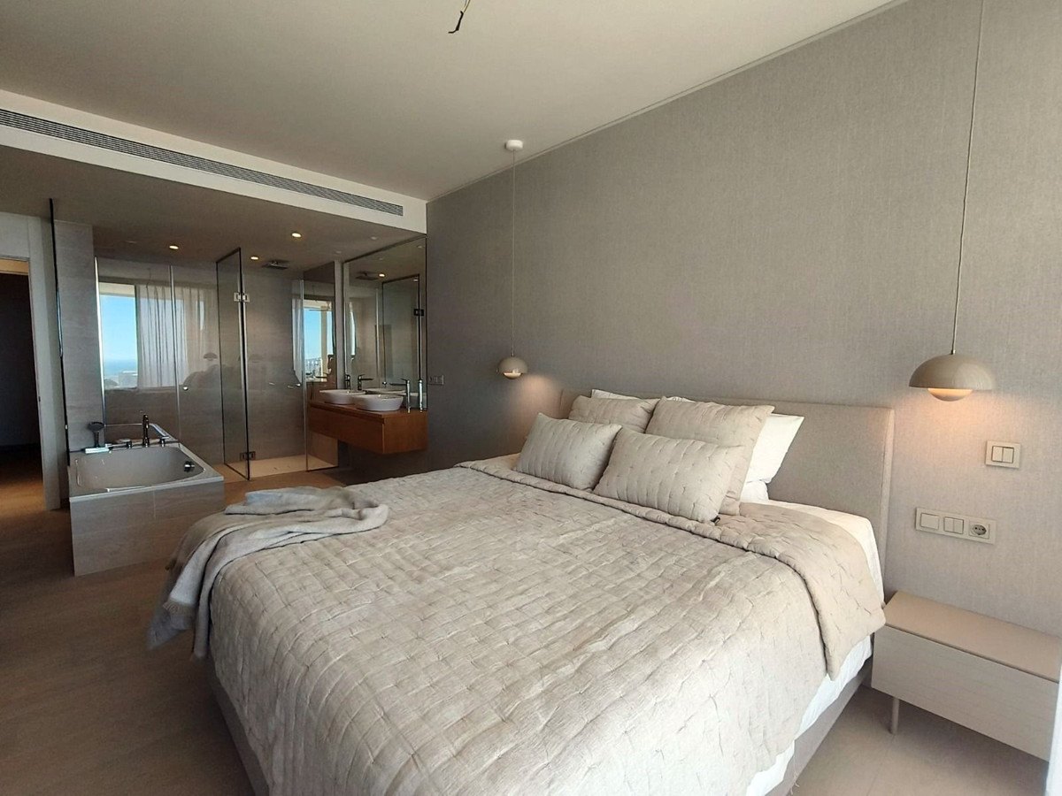 The main bedroom with its bathroom behind a glass wall