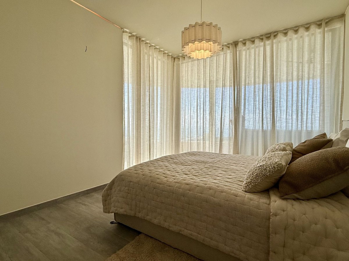 A bedroom behind sheer curtains