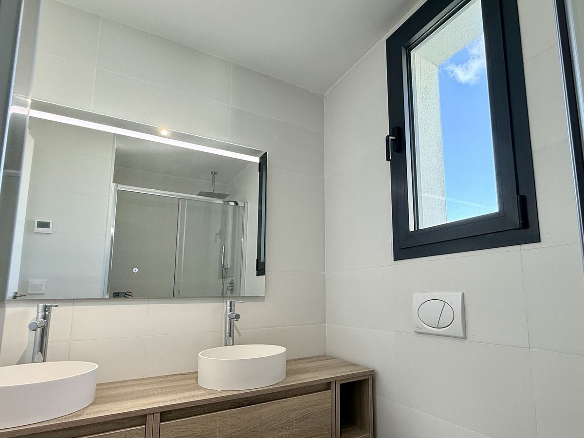 Bathroom with twin basins and a lit mirror