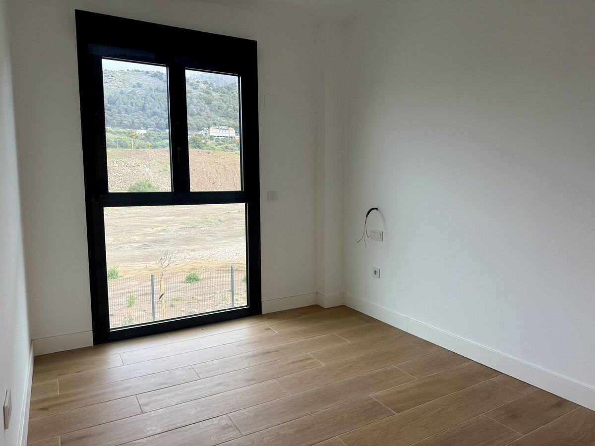 A bedroom, the hills in the tall window