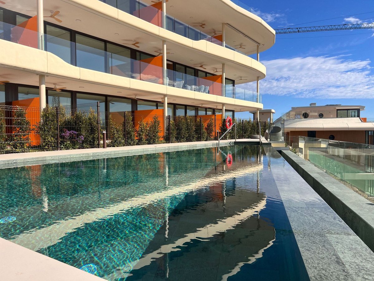 A lap pool running beside the curved white balconies