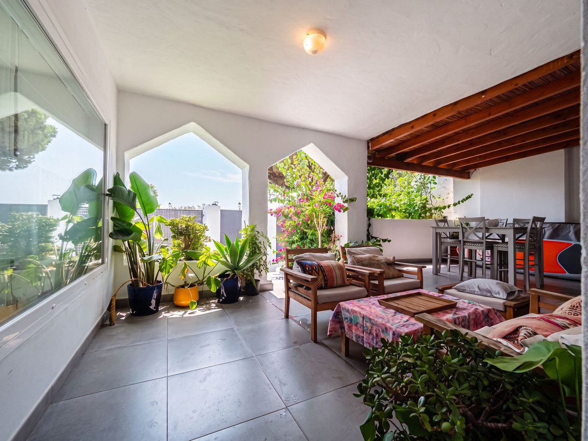 Sofas on the covered porch, the pointed windows behind