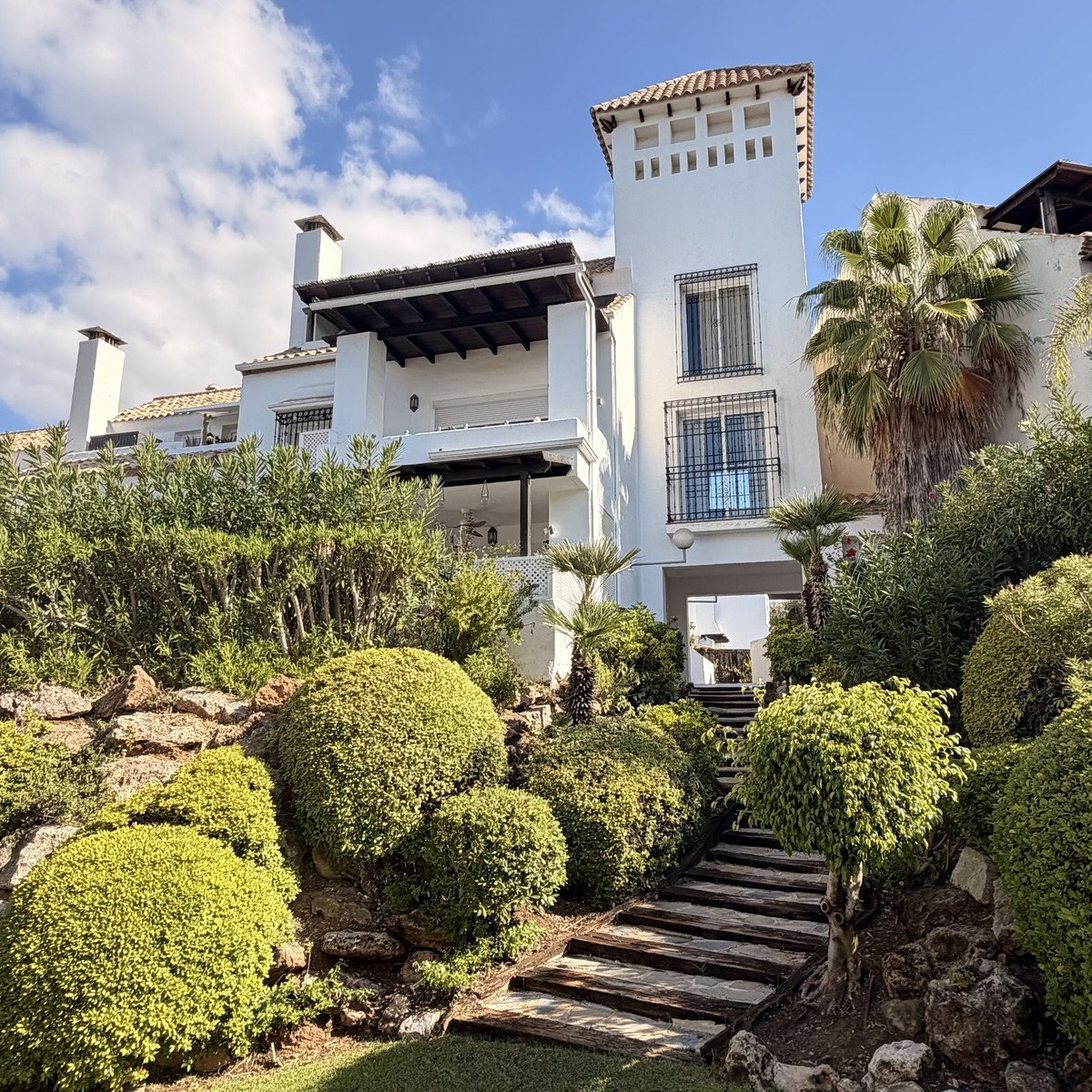 The white façade and the Andalusian tower, above the garden steps